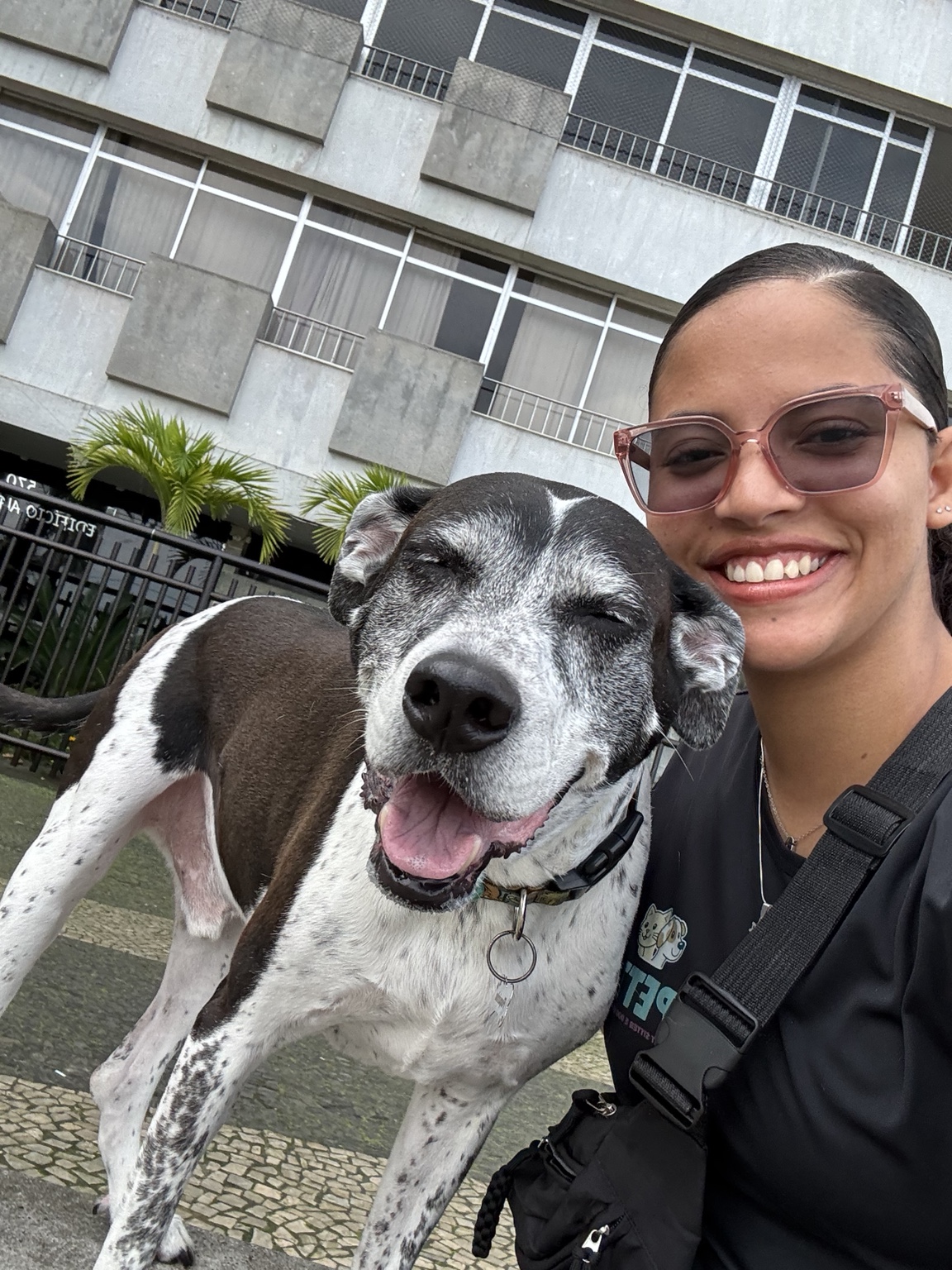 Gabrielle ao lado de um cão preto e branco durante um passeio individual