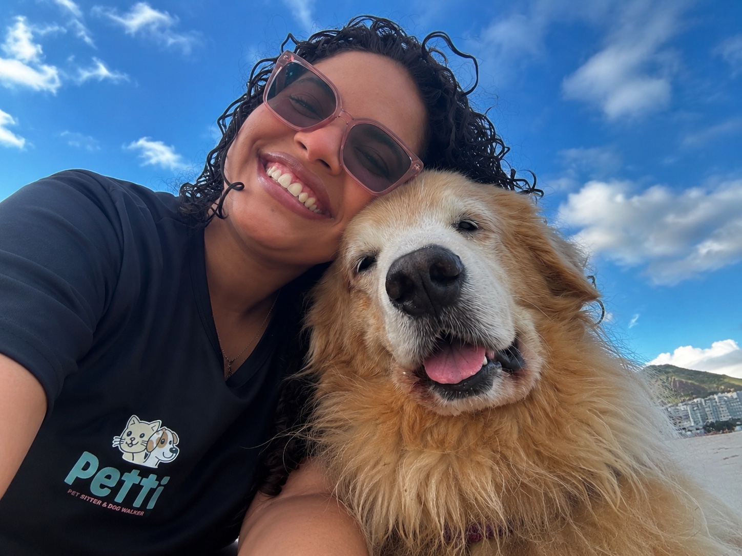 Gabrielle sorrindo ao lado de um Golden Retriever em um momento de carinho